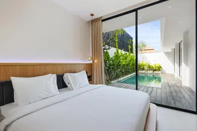a bedroom with a bed and a view of a pool at New 3 BR Luxury Villa in Umalas in Canggu