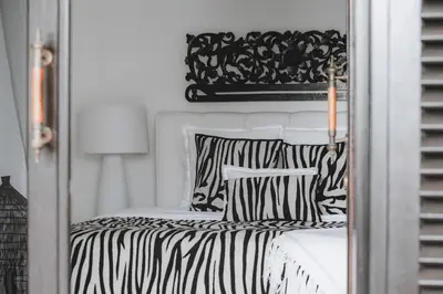 a bed with black and white sheets and pillows at Villa Manis Kecil in Seminyak