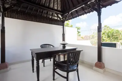 a black desk and chair in a room with a window at Villa Manis Kecil in Seminyak