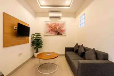 a living room with a couch and a table at Adikara Apartment by Betterplace in Canggu