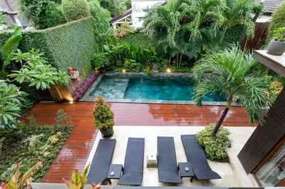 a swimming pool in the middle of a garden at Villa Eden - Seminyak in Seminyak