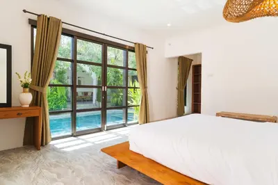 a bedroom with a bed and a large window at Villa Nirvana Seminyak in Seminyak