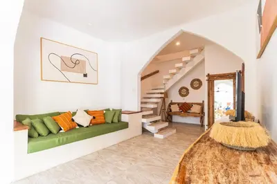 a living room with a green couch and stairs at Villa Nirvana Seminyak in Seminyak