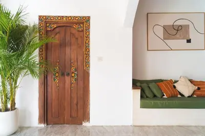 a wooden door in a living room with a couch at Villa Nirvana Seminyak in Seminyak