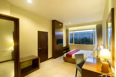 a hotel room with a bed and a desk at Seminyak Square Hotel And Villas in Seminyak