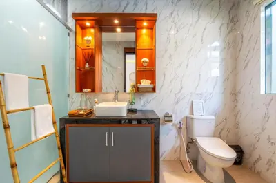 a bathroom with a toilet and a sink and a mirror at Villa Taj - Luxury 3-bedroom Pool Villa Near Seminyak in Kerobokan