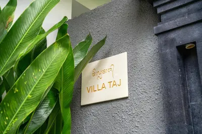 a sign on the side of a building with green leaves at Villa Taj - Luxury 3-bedroom Pool Villa Near Seminyak in Kerobokan