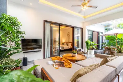 a living room with a couch and a tv at Villa Taj - Luxury 3-bedroom Pool Villa Near Seminyak in Kerobokan