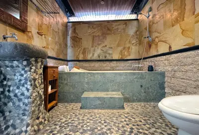 a bathroom with a tub and a toilet and a sink at Villa Mutti in Seminyak