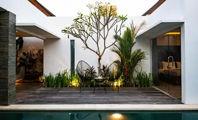 a patio with a table and chairs next to a pool at Villa Yolanda - Seminyak Beach in Seminyak