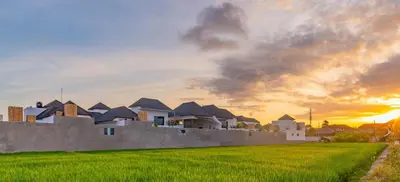 a villa with a wall and green grass at Villa Yolanda - Seminyak Beach in Seminyak
