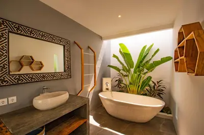 a bathroom with a tub and a sink and a plant at Villa Yolanda - Seminyak Beach in Seminyak