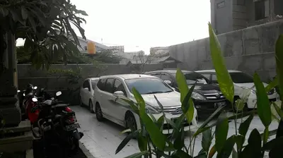 a group of cars parked in a parking lot at Kubu Carik in Legian