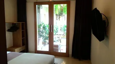 a bedroom with a sliding glass door to a patio at Kubu Carik in Legian