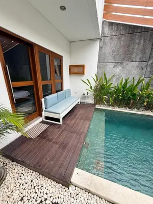 a patio with a blue couch and a swimming pool at Villa Leyan 1 Semer - Between Seminyak & Canggu in Seminyak