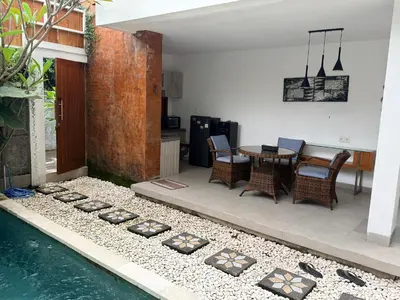 a backyard with a pool and a table and chairs at Villa Leyan 1 Semer - Between Seminyak & Canggu in Seminyak