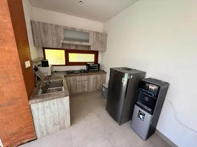a small kitchen with a refrigerator and a sink at Villa Leyan 1 Semer - Between Seminyak & Canggu in Seminyak