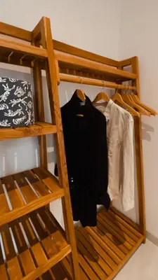 a wooden bunk bed with clothes hanging on it at Villa Hope Bali in Kerobokan
