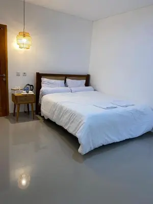 a bedroom with a large bed and a table at Home Stay Room In Bali Near Sanur Beach in Sanur