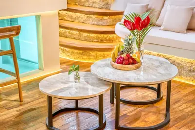 two tables with a bowl of fruit and a vase of flowers at Villa Orlando - Brand New 9BR Jacuzzi Cinema in Seminyak