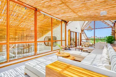 a living room with white furniture and large windows at Villa Orlando - Brand New 9BR Jacuzzi Cinema in Seminyak