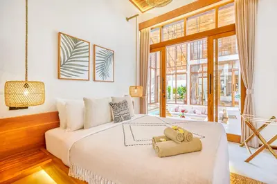 a bedroom with a large bed and a large window at Villa Orlando - Brand New 9BR Jacuzzi Cinema in Seminyak