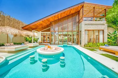 an exterior view of a house with a swimming pool at Villa Orlando - Brand New 9BR Jacuzzi Cinema in Seminyak