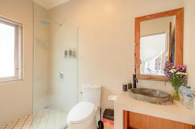 a bathroom with a toilet and a sink and a mirror at Villa Toto Seminyak in Seminyak