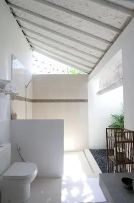 a white bathroom with a toilet and a window at AMAZING 1 BR Villa Private Pool walk to beach in Seminyak