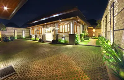 a house with a lit up courtyard at night at The Banyumas Suite Villa Legian in Legian