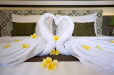 two swans made out of towels on a bed at The Banyumas Suite Villa Legian in Legian