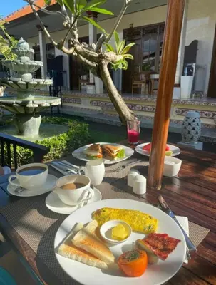a breakfast of eggs and toast on a table at Frangipani Homestay in Nusa Dua
