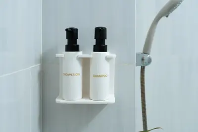 two bottles ofodorizers on a shelf in a bathroom at The Kifaraju Nusa Dua Bali in Nusa Dua
