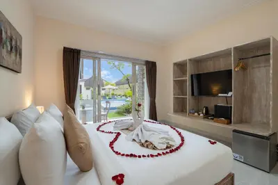 a bedroom with a large bed with a large window at The Kifaraju Nusa Dua Bali in Nusa Dua