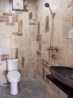 a bathroom with a toilet and a sink at Villa with private pool and garden in Nusa Dua 3BR in Nusa Dua