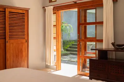 a bedroom with an open door to a patio at Villa with private pool and garden in Nusa Dua 3BR in Nusa Dua