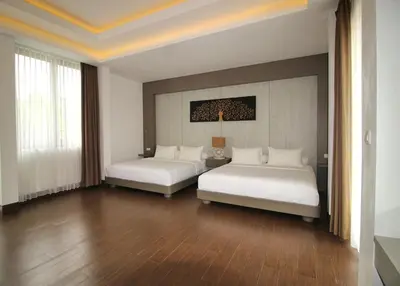 a hotel room with two beds and a table at Villa Maisha by REJA Villas in Nusa Dua