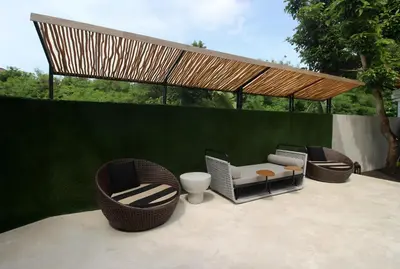 a patio with chairs and a table and a fence at Villa Maisha by REJA Villas in Nusa Dua