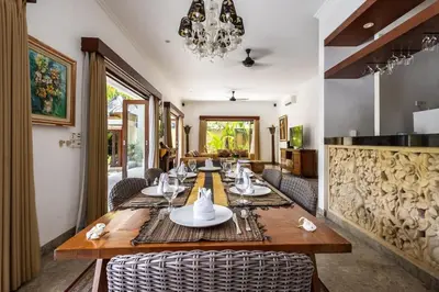 a dining room with a long wooden table and chairs at Luxury 3-Bedroom Villa With Private Pool Seminyak Village in Seminyak