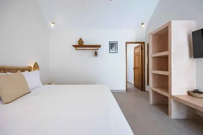 a white bedroom with a bed and a tv at Casa Kokoon - NEW Bright & Quiet 2BR Mertanadi Seminyak with Private Pool and Parking in Seminyak