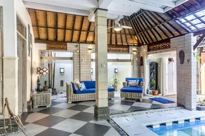 an outdoor living area with a pool and a patio with wicker furniture at Villa Nari - GG100X Seminyak, Bali in Seminyak