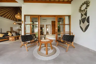 a living room with two chairs and a table at Villa Kepompong Seminyak - 1BR Private Pool Villa in Seminyak