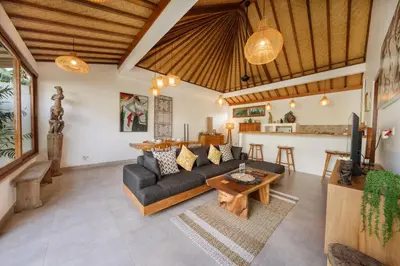 a living room with a couch and a table at Villa Kepompong Seminyak - 1BR Private Pool Villa in Seminyak