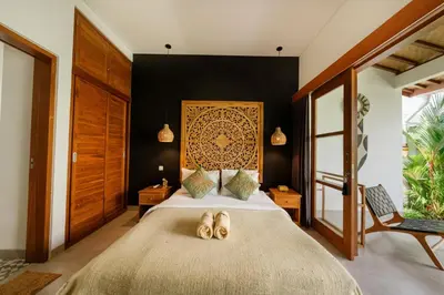a bedroom with a bed with two pairs of shoes on it at Villa Kepompong Seminyak - 1BR Private Pool Villa in Seminyak