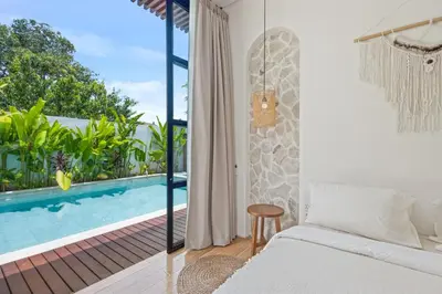 a bedroom with a bed and a swimming pool at Mediterranean 2BR Villa Ellure Ember with Pool & Lush Garden in Jimbaran