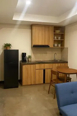 a kitchen with a black refrigerator and a table at Alzeto Coliving in Legian