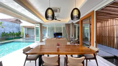 a dining room with a table and a swimming pool at YY Villa Seminyak - 4BR Luxury Private Villa in Seminyak