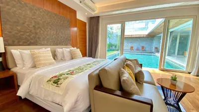 a bedroom with a large bed and a large window at YY Villa Seminyak - 4BR Luxury Private Villa in Seminyak