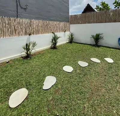 four surfboards laying on the grass in a yard at Wakajima House Kuta Utara in Kerobokan
