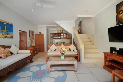 a living room with a couch and a table at Legian Blue Ocean Villa in Seminyak